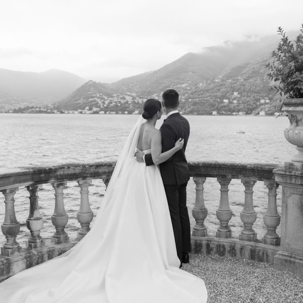 Pareja en balcón de villa junto al lago de Como, foto editorial de boda en blanco y negro con luz natural