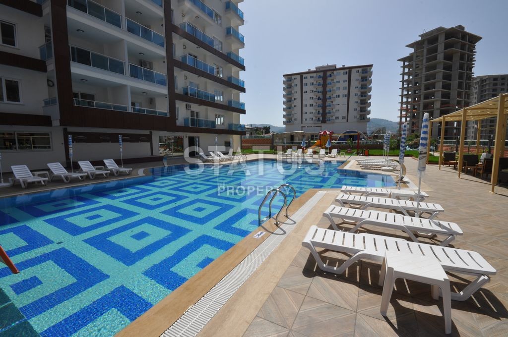 Furnished spacious one-bedroom apartment in a complex with a swimming pool in Mahmutlar, 75 m2. фото 1