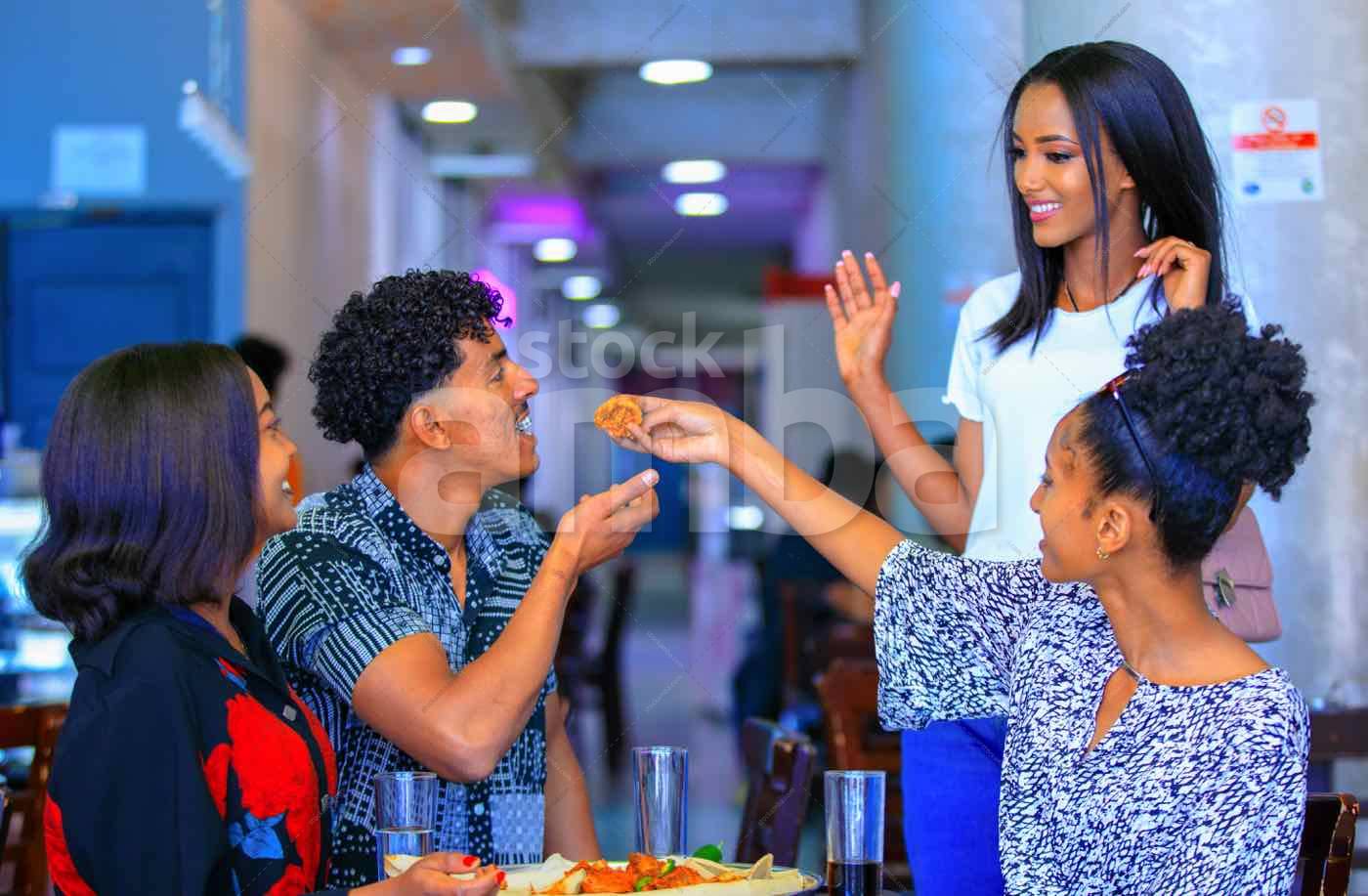 Cheerful Friends Sharing Food Together - StockAMBA.com